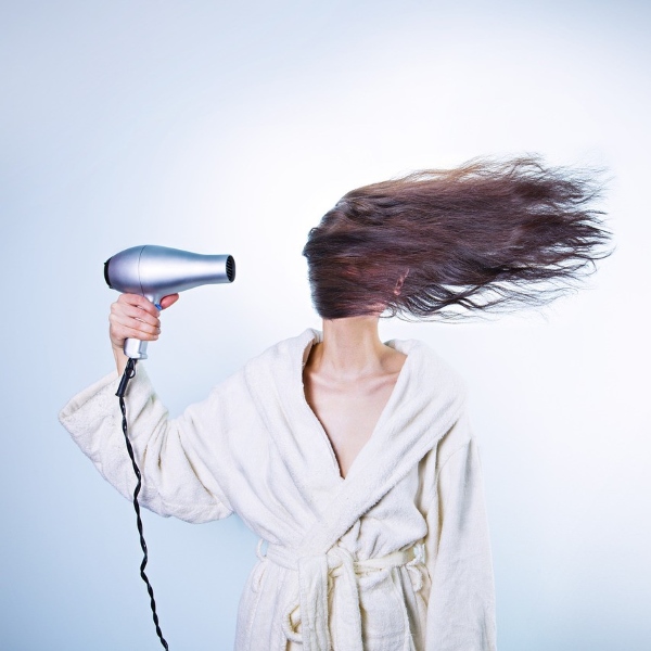 ragazza con il phon per capelli
